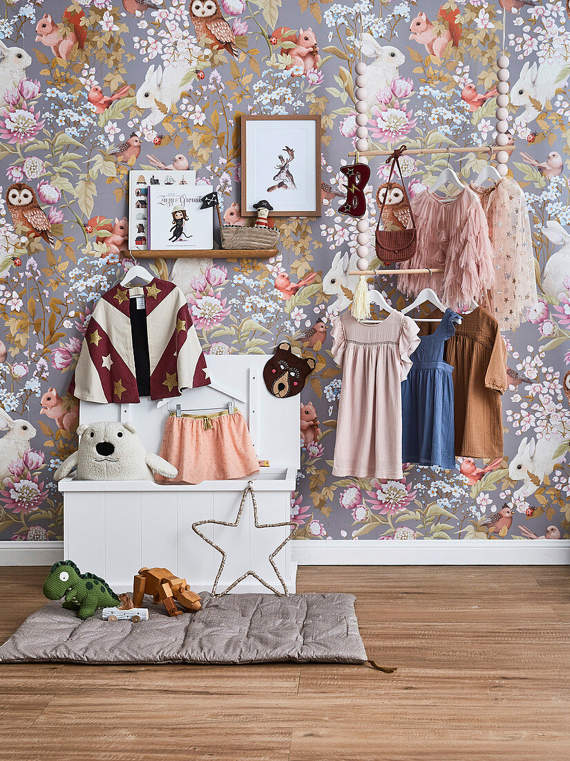 Hanging cloakroom in front of a wallpaper with fairytale wildlife