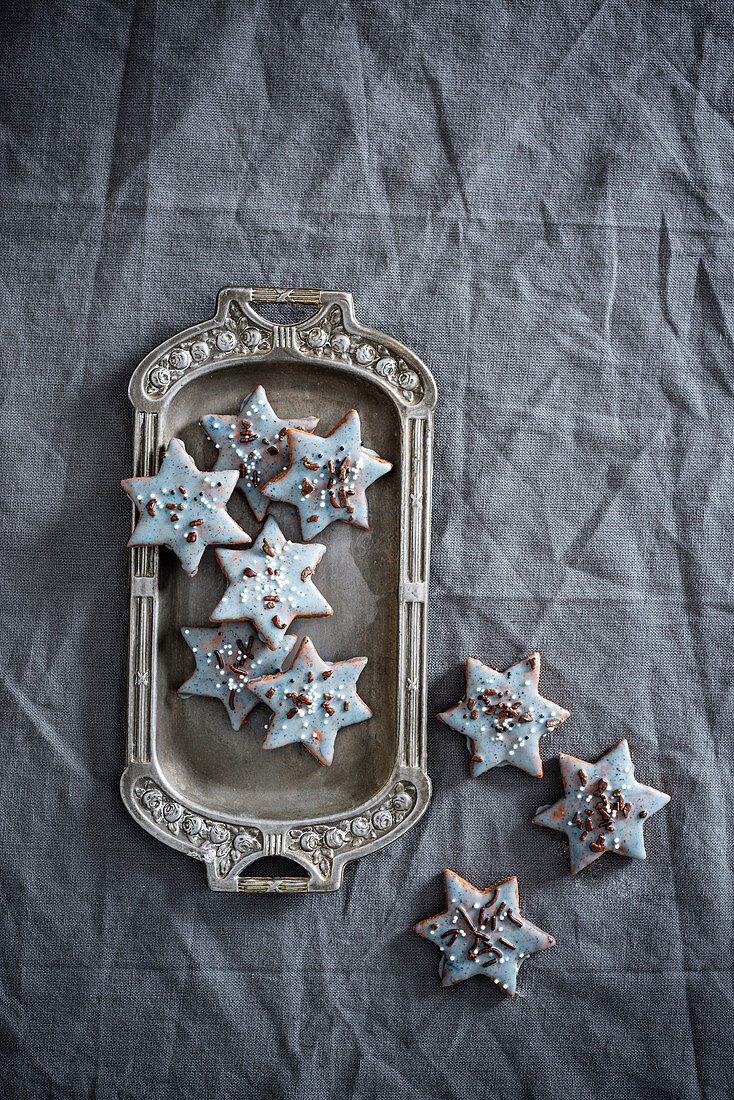 Star-shaped vegan biscuits with pale blue icing and sugar pearls