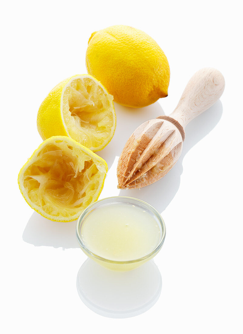 Zitronensaft und ausgepresste Zitronen