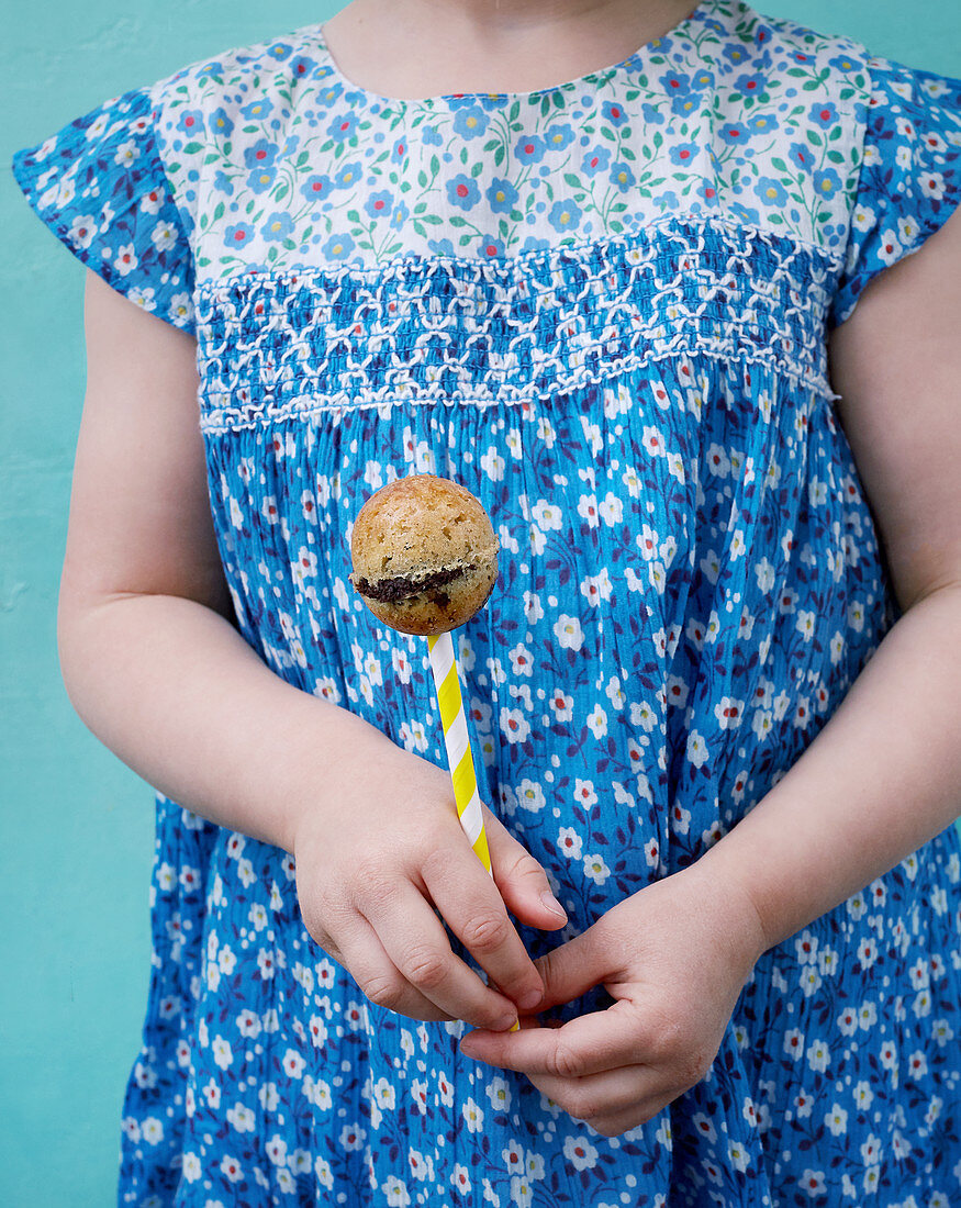 A little girl holding a marble cake pop
