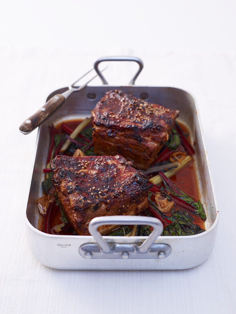 Braised pork belly with with chard in a roasting tin