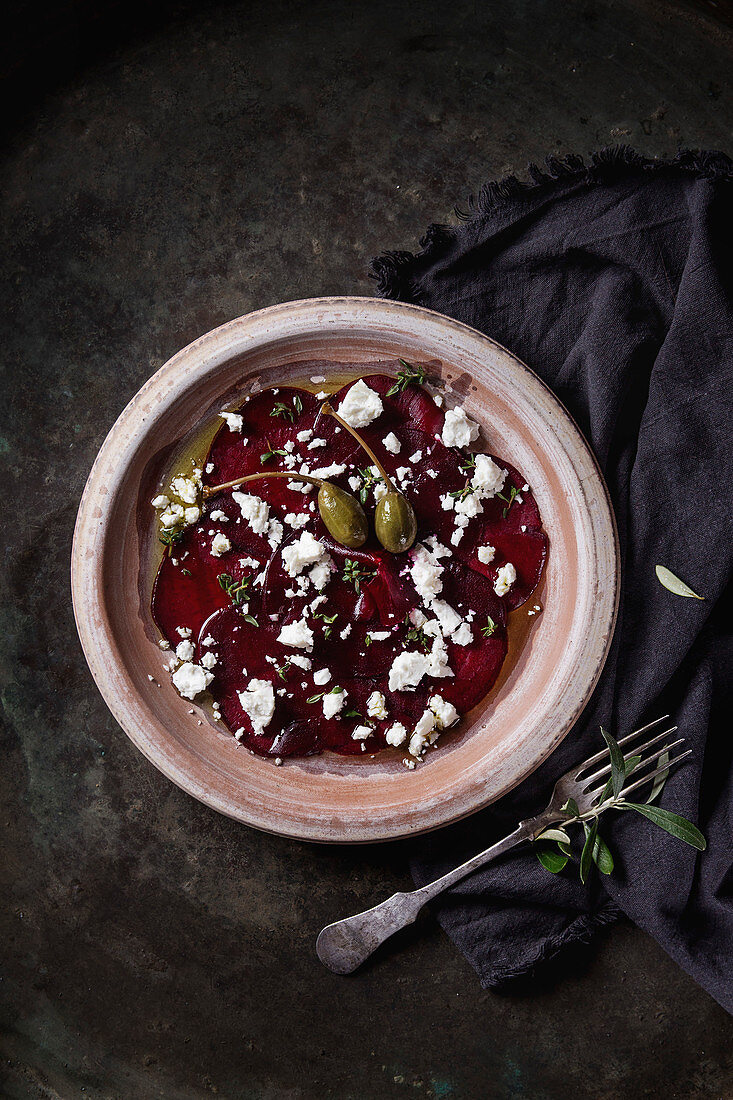 Vegetarian beetroot carpaccio salad with feta cheese, thyme, olive oil and capers