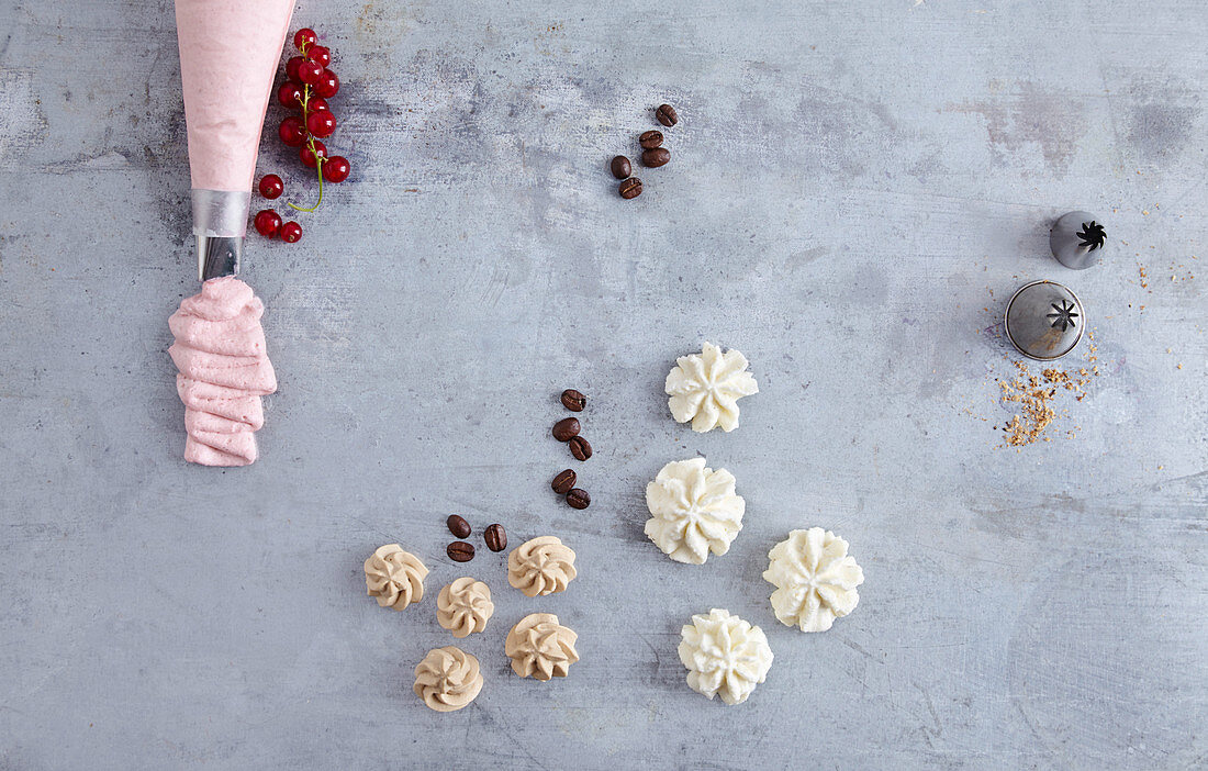 A piping bag and piped rosettes with fruit cream, coffee cream and tonka bean cream