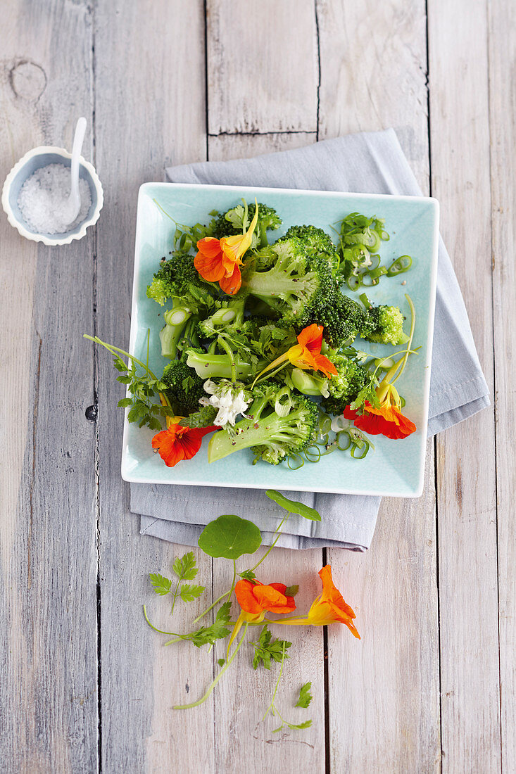 Warm broccoli salad with fresh wild herbs and edible flowers