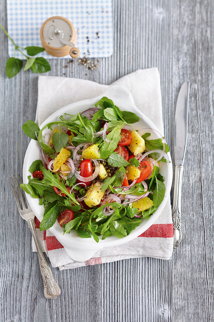 Tomato and pineapple salad with rocket and fresh herbs
