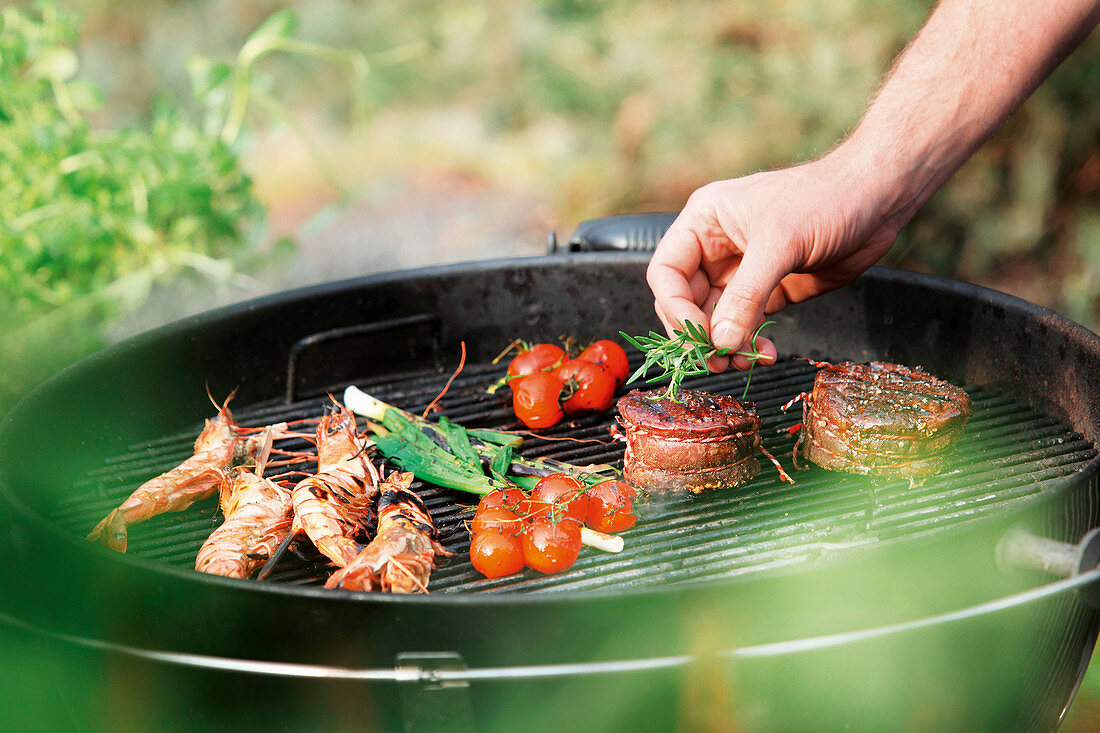 Langoustines, tomatoes and garnished medallions on a barbecue