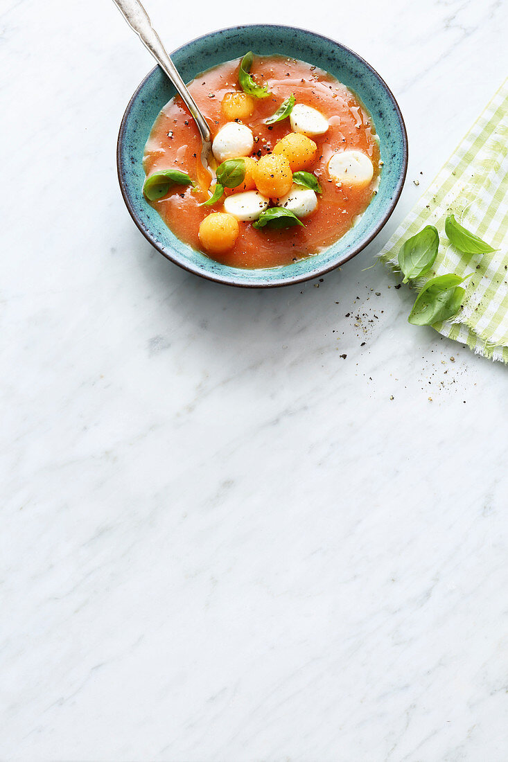 Cold tomato soup with melon and mozzarella balls