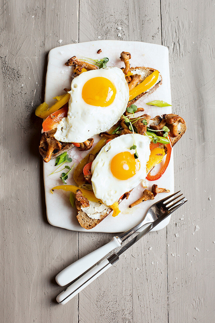 Grilled bread topped with vegetables and fried eggs for vegetarians
