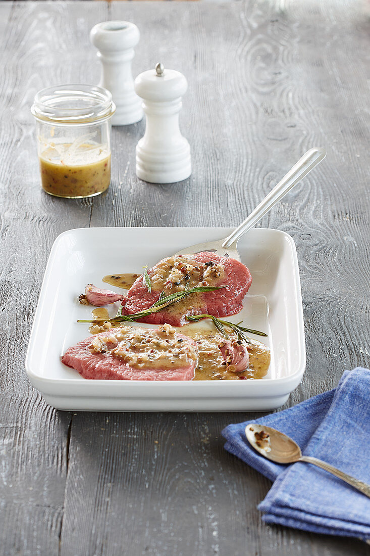 Raw steaks with a pepper marinade