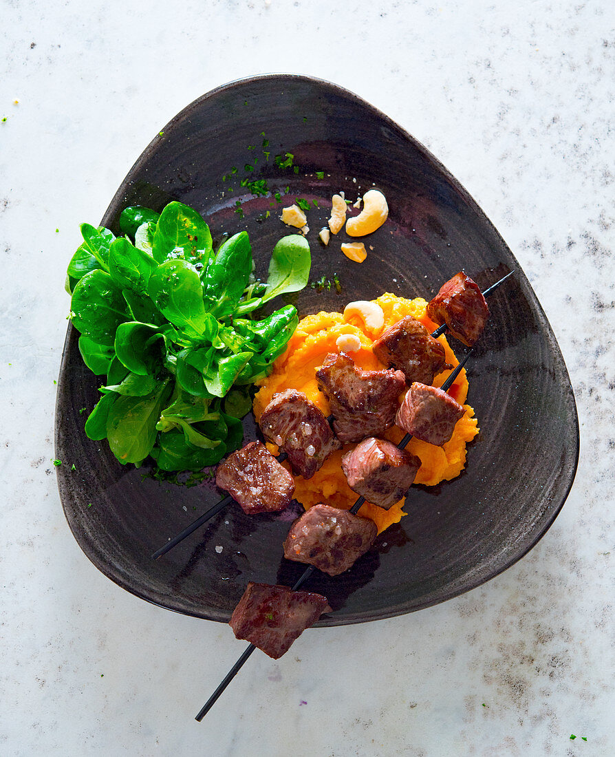 Beef skewers with mashed sweet potatoes and lamb's lettuce