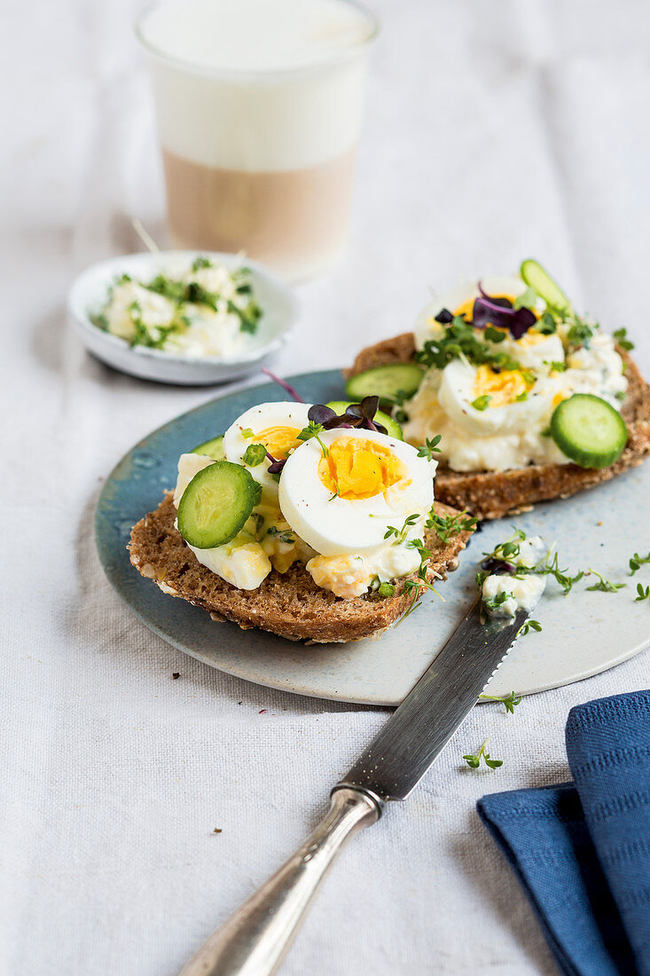 Wholemeal roll topped with herb cream cheese and hard-boiled egg