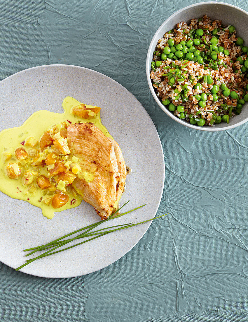 Chicken breast fillets with peas, bulgur wheat, and apricot curry sauce