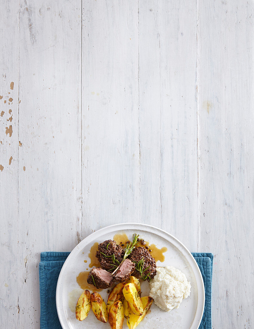 Roasted lamb with a linseed crust, baked potatoes and cauliflower purée