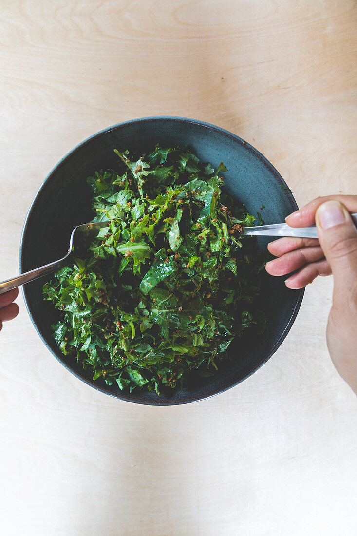 Making a kale salad with bread crumbs and lemon vinaigrette