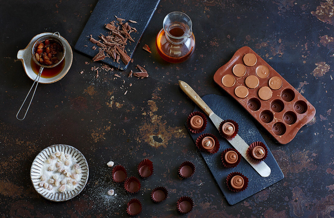 Pralines in moulds, rum-soaked raisins and chopped cooking chocolate