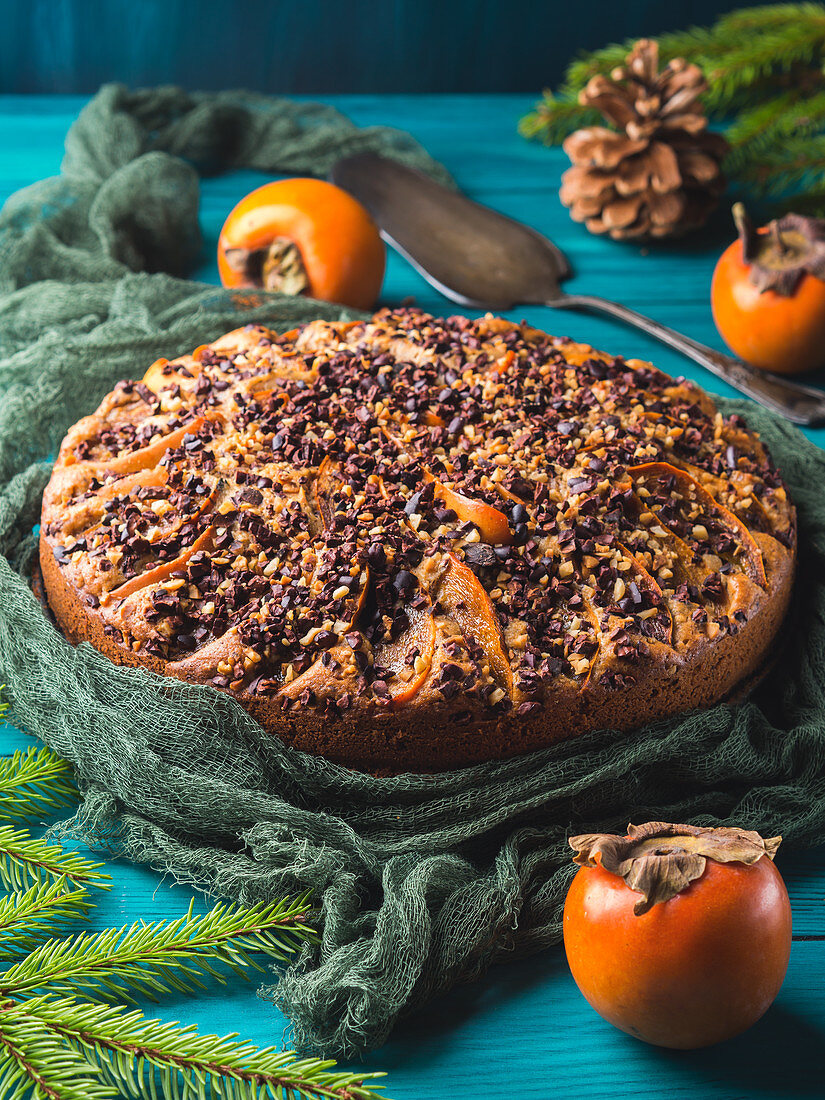 Whole wheat cake with persimmons topped with raw cocoa nibs and walnuts