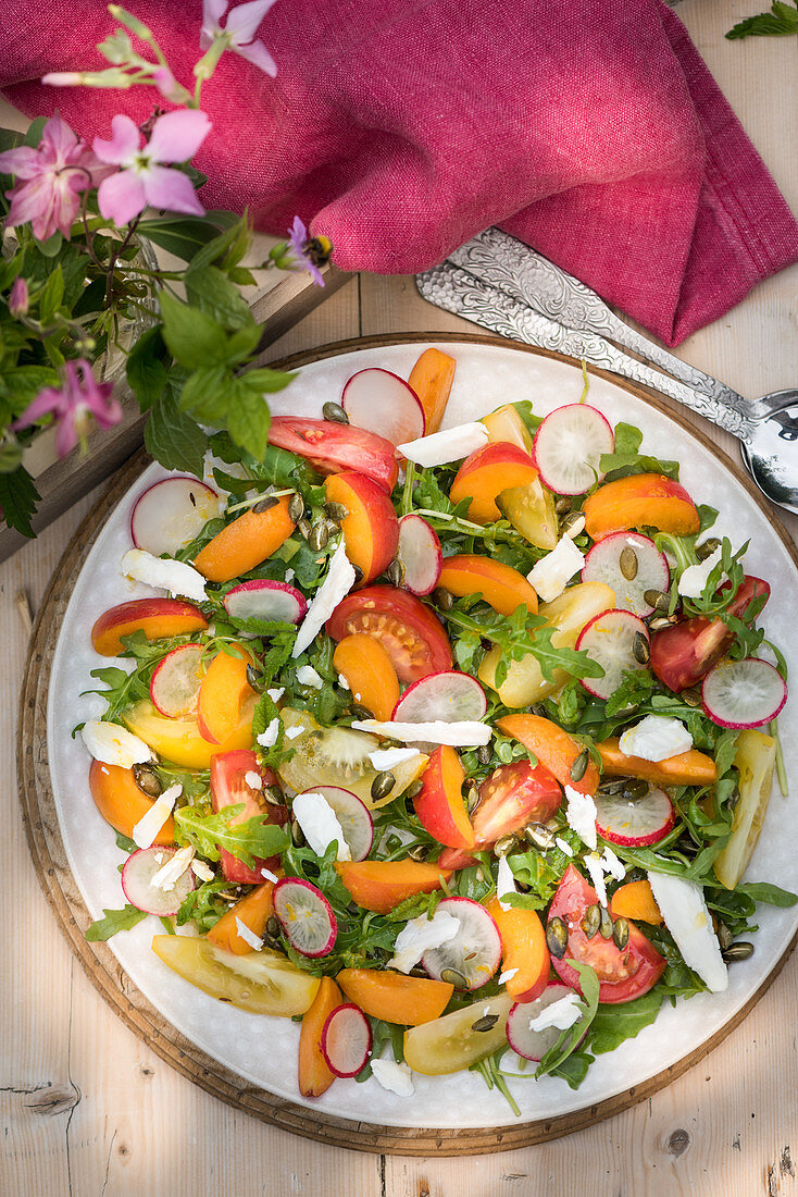 Sommerlicher Rucola-Aprikosen-Salat mit Tomaten, Radieschen und Ziegenkäse