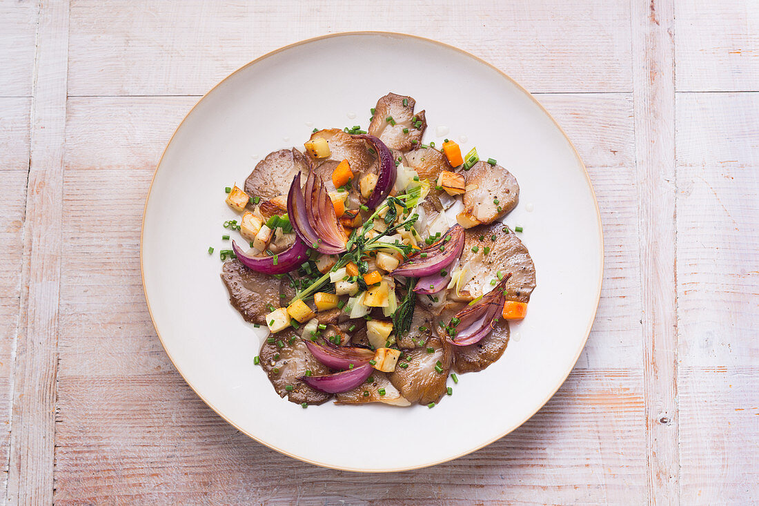 Fried oyster mushrooms on a bed of oven-roasted vegetables