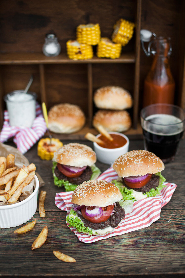 Mini-Burger mit Pommes frites, gegrilltem Mais, selbstgemachtem Ketchup und dunklem Bier