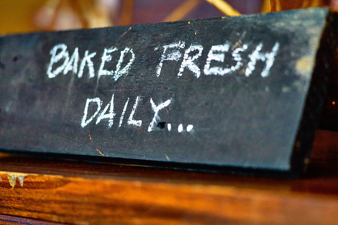 The words 'Baked Fresh Daily' on a slate sign