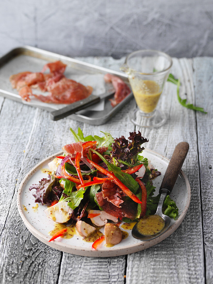 Colourful summer salad with Serrano ham and mushrooms