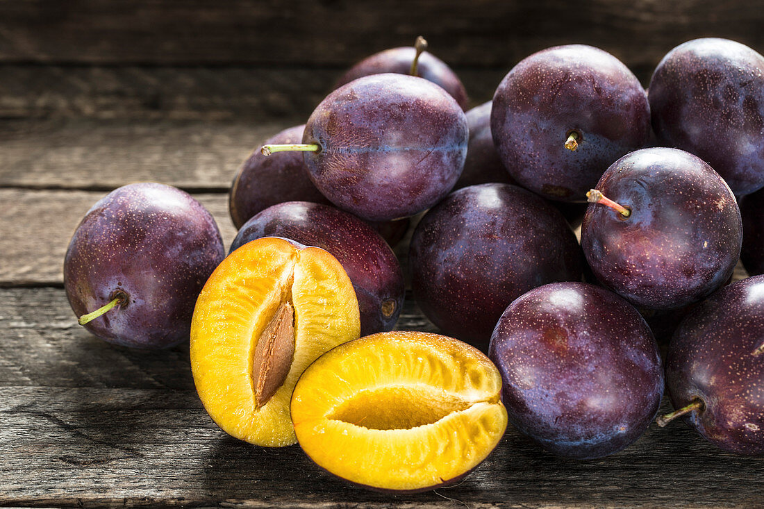 Delicious fresh blue plums on wooden table