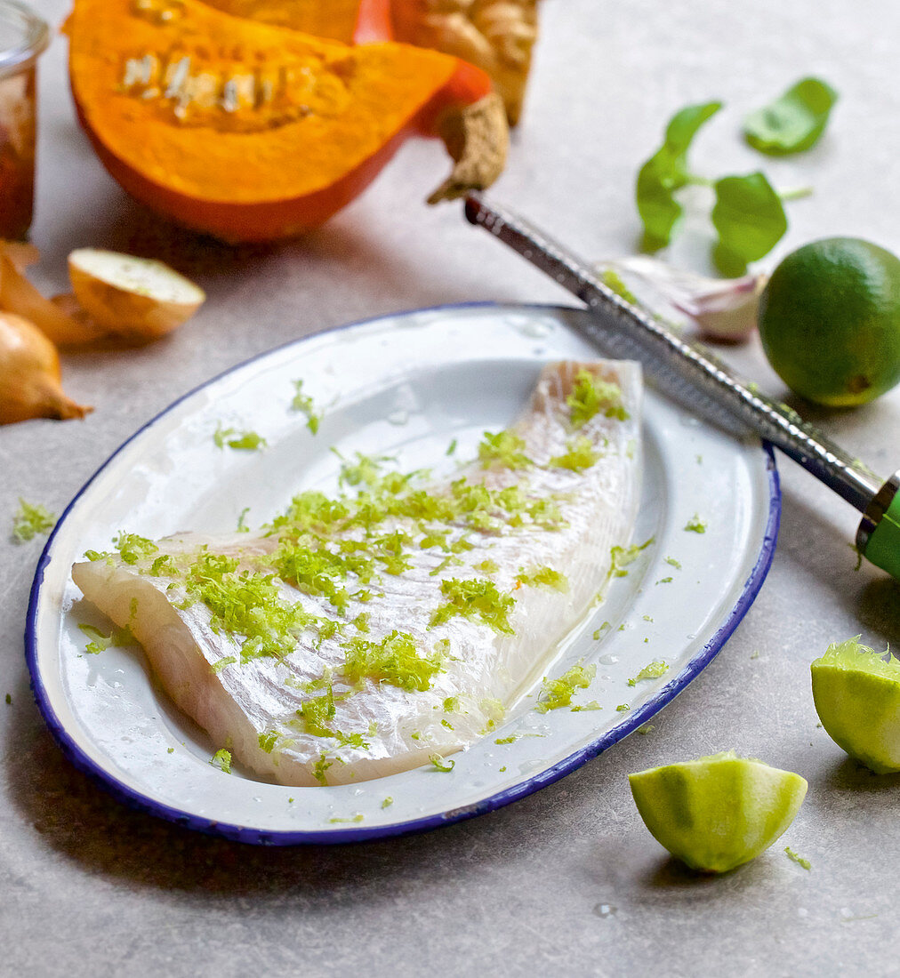 A raw cod fillet topped with lime zest