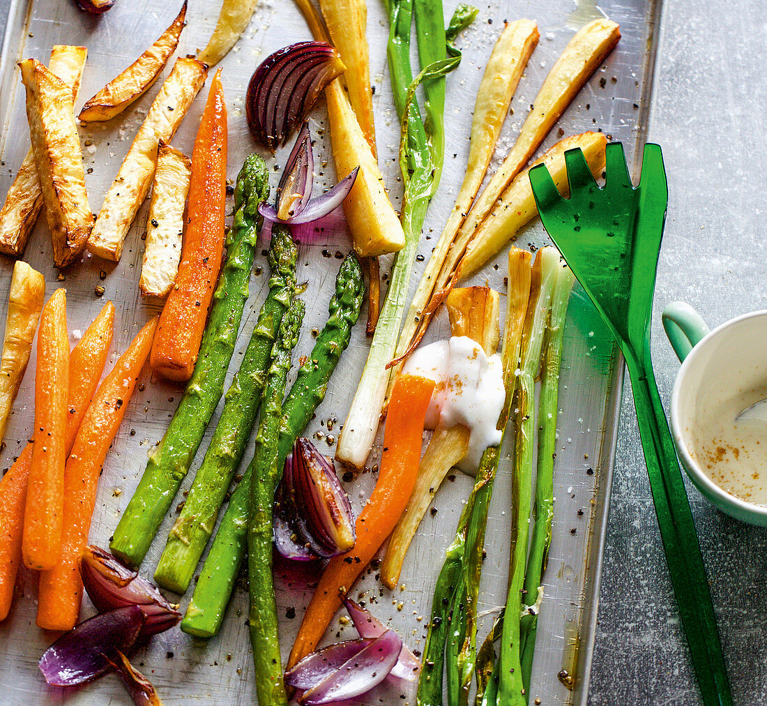 Colourful oven-roasted vegetables including asparagus, carrots, pumpkin and parsnips