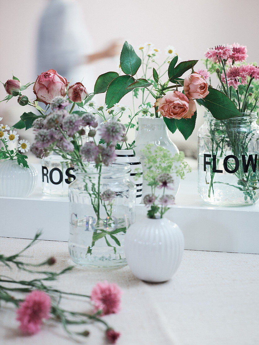 Homemade vases made from screw-top jars with stick-on flowers