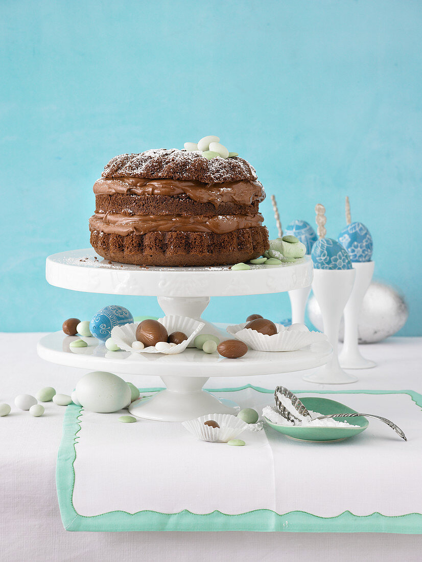 Chocolate cake on a cake stand with chocolate Easter eggs