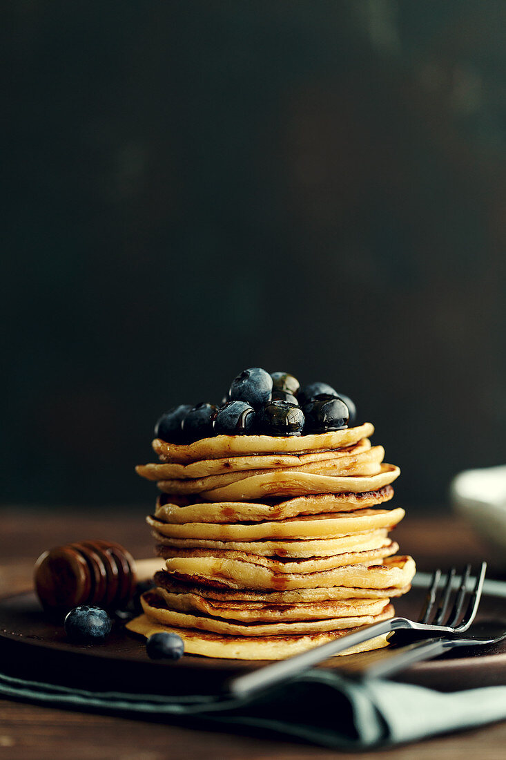 Ein Stapel Pancakes mit Blaubeeren und Ahornsirup