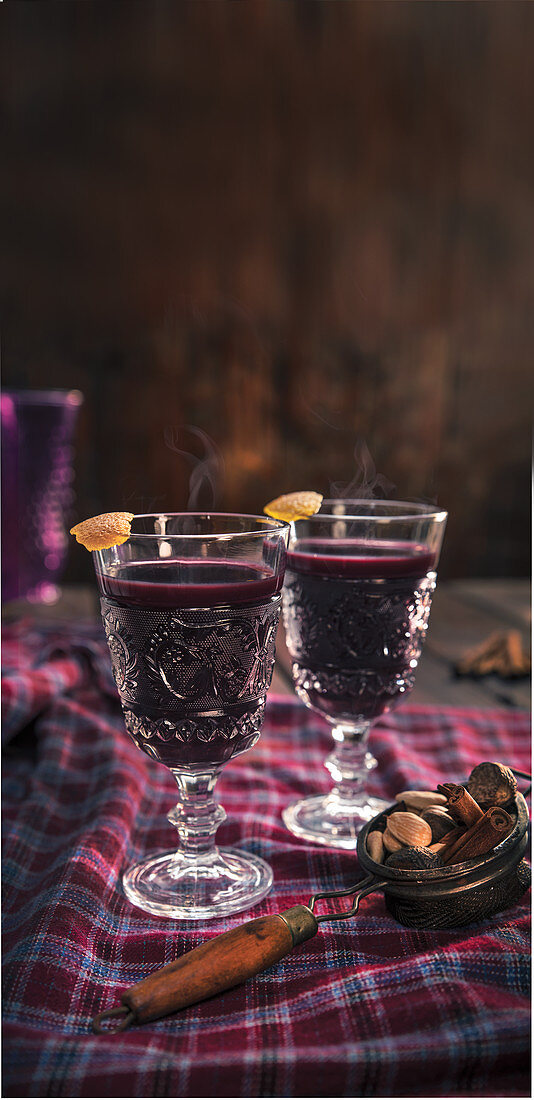 Mulled wine with spices and orange peel, served in stemmed glasses