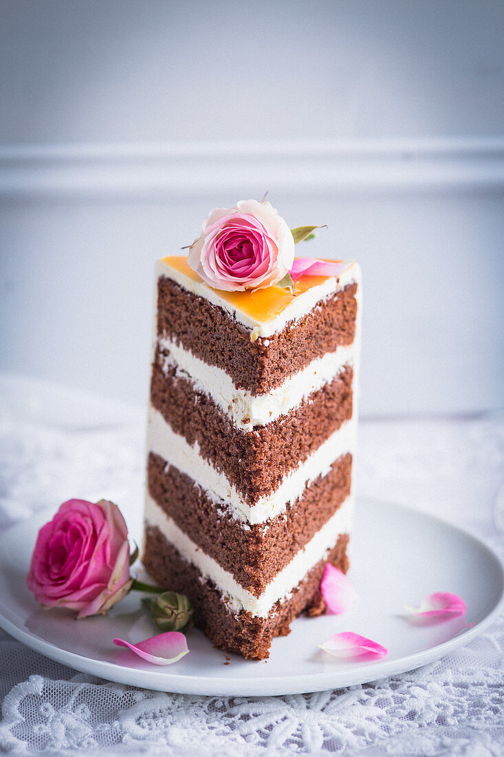 Ein Hochzeitstortenstück dekoriert mit Rosenblüten