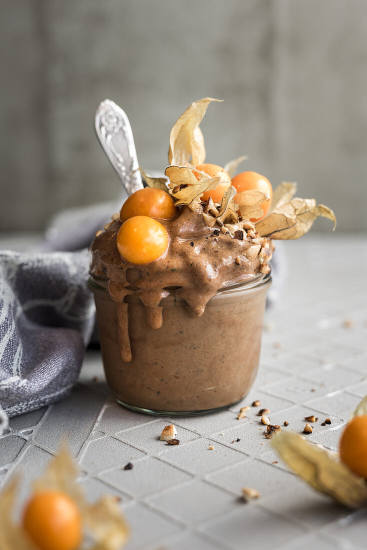 A frozen banana smoothie with cocoa, physalis and almonds