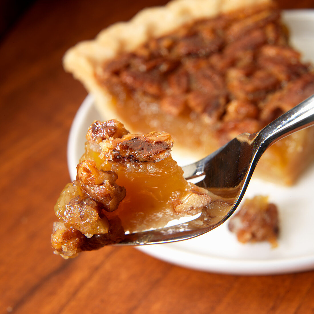 Pecan pie on fork in front of pie slice