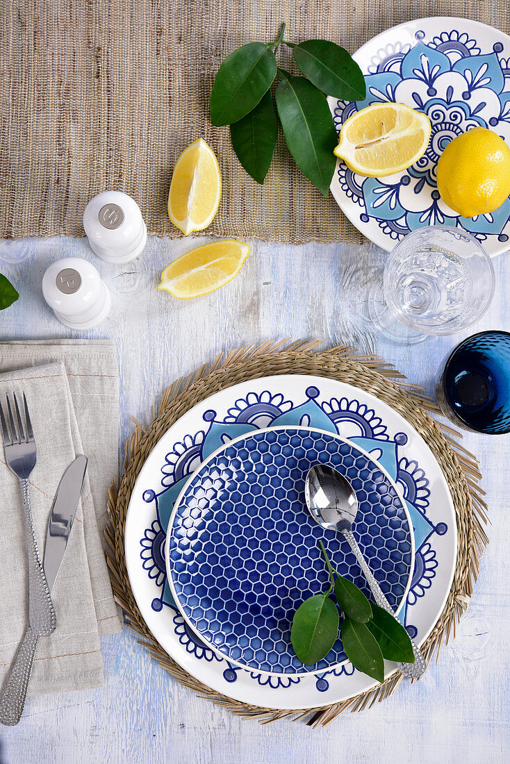 A maritime place setting in blue and white with lemons