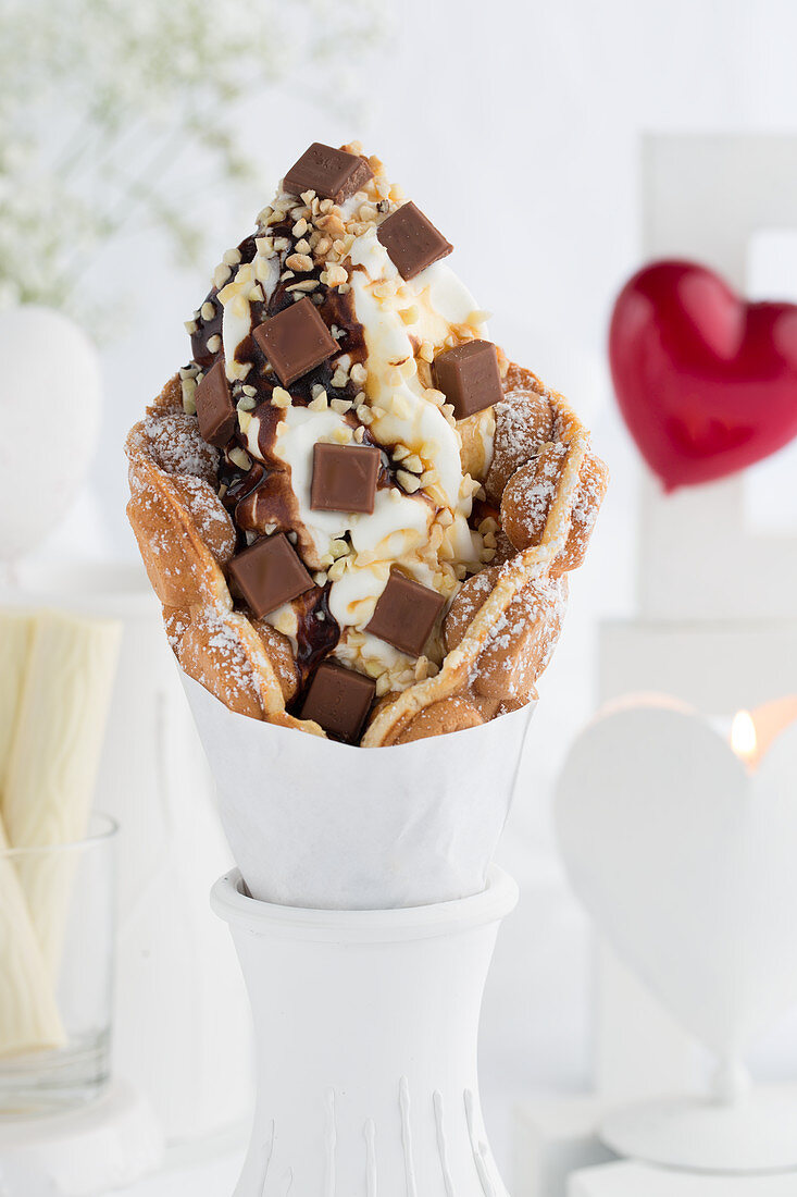 A bubble waffle with hazelnuts, chocolate pieces and chocolate sauce