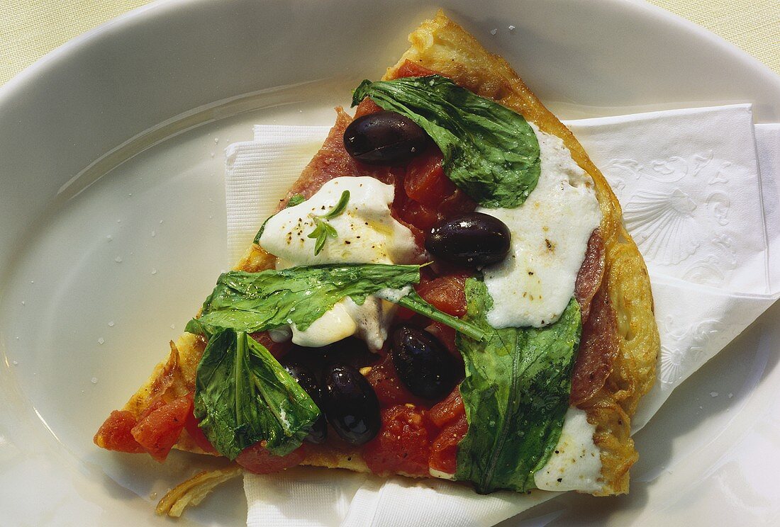 Spaghetti pizza slice with olives, tomatoes, mozzarella, rocket
