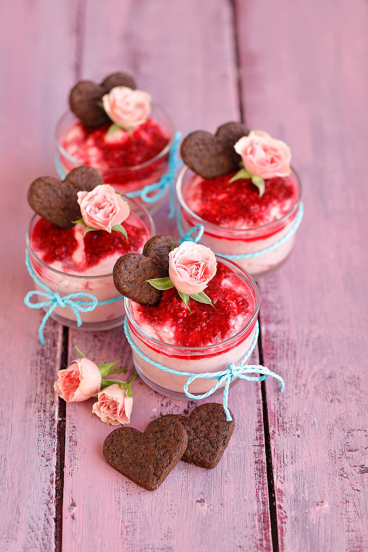 Raspberry mousse decorated with rose petals and heart-shaped biscuits