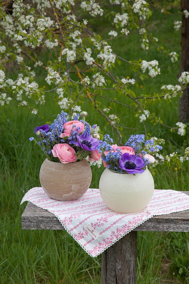 Kugelvasen mit Frühlngsblumen im Garten