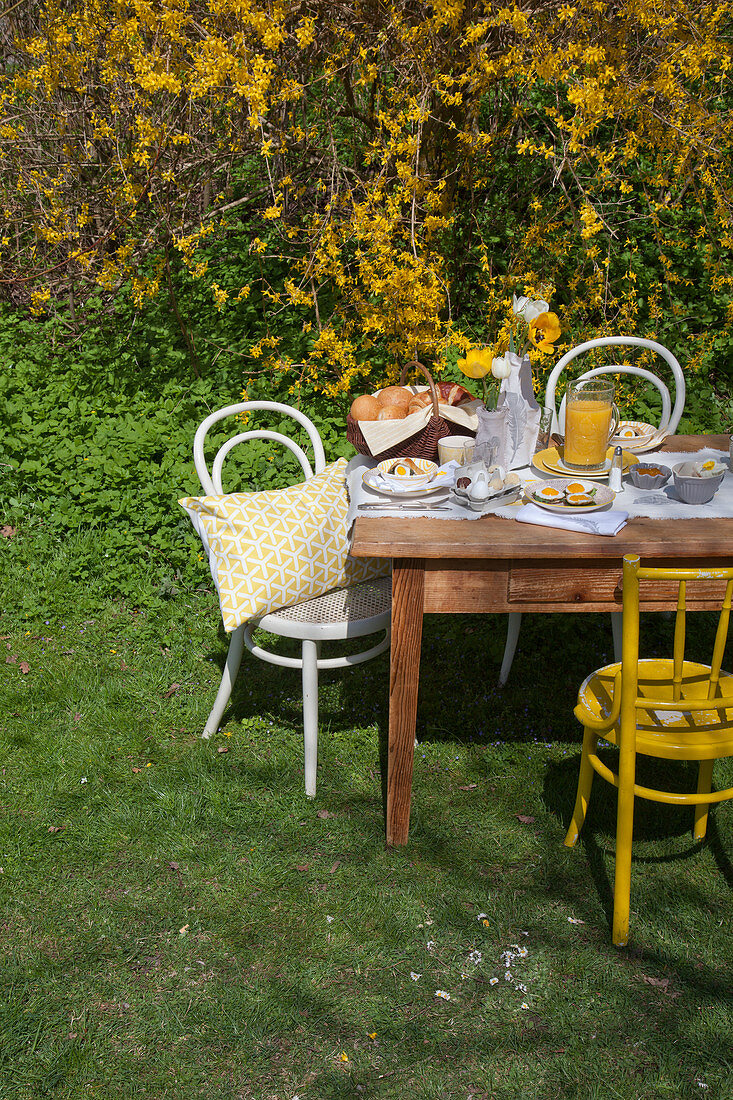 Fürs Osterfrühstück gedeckter Tisch im Garten