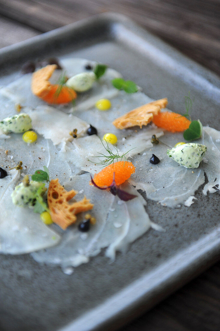 Fish carpaccio with caviar, herb butter, and bread