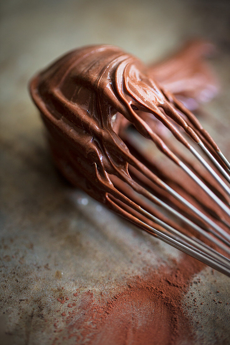 A whisk covered with chocolate cream