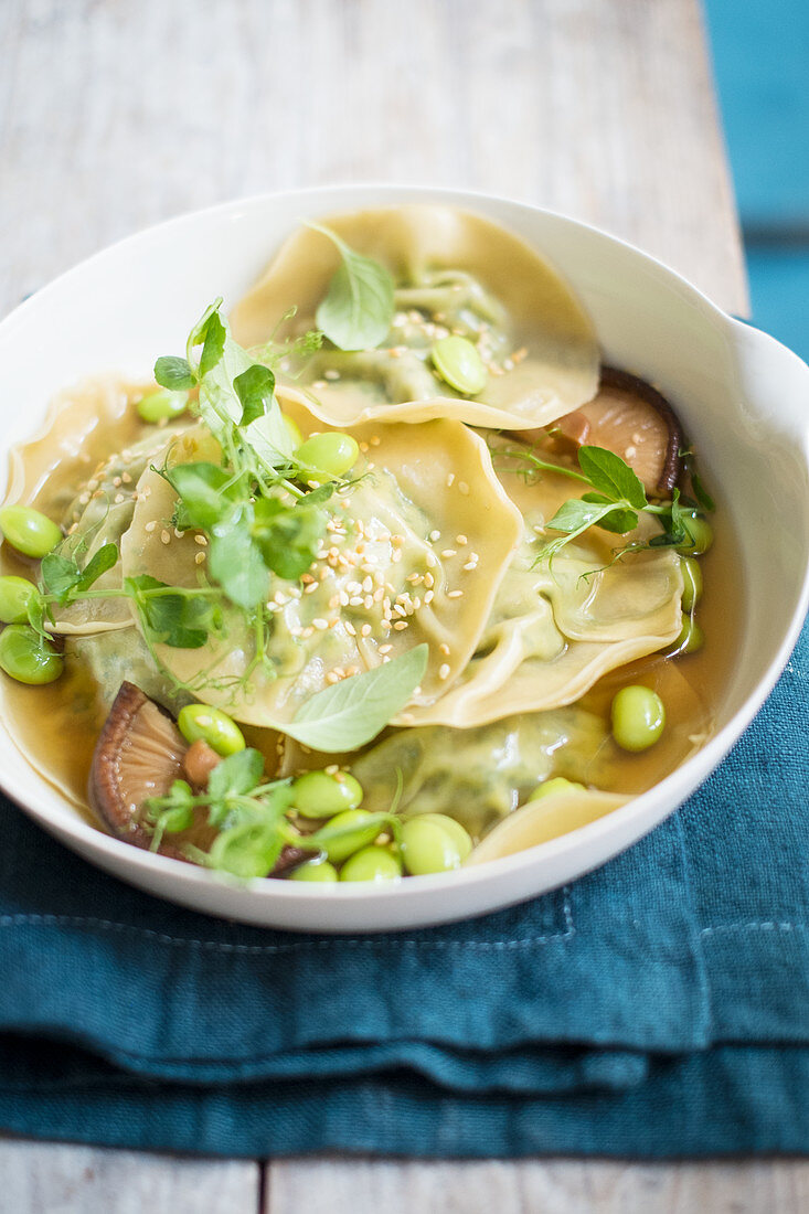 Dumplings in Brühe mit Edamame, Pilzen und Brunnenkresse