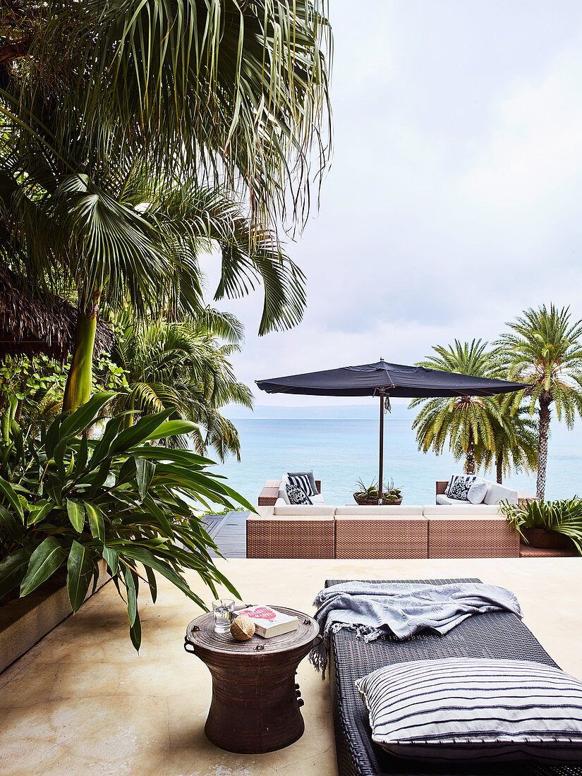 Outdoor bed and side table on terrace with sea view