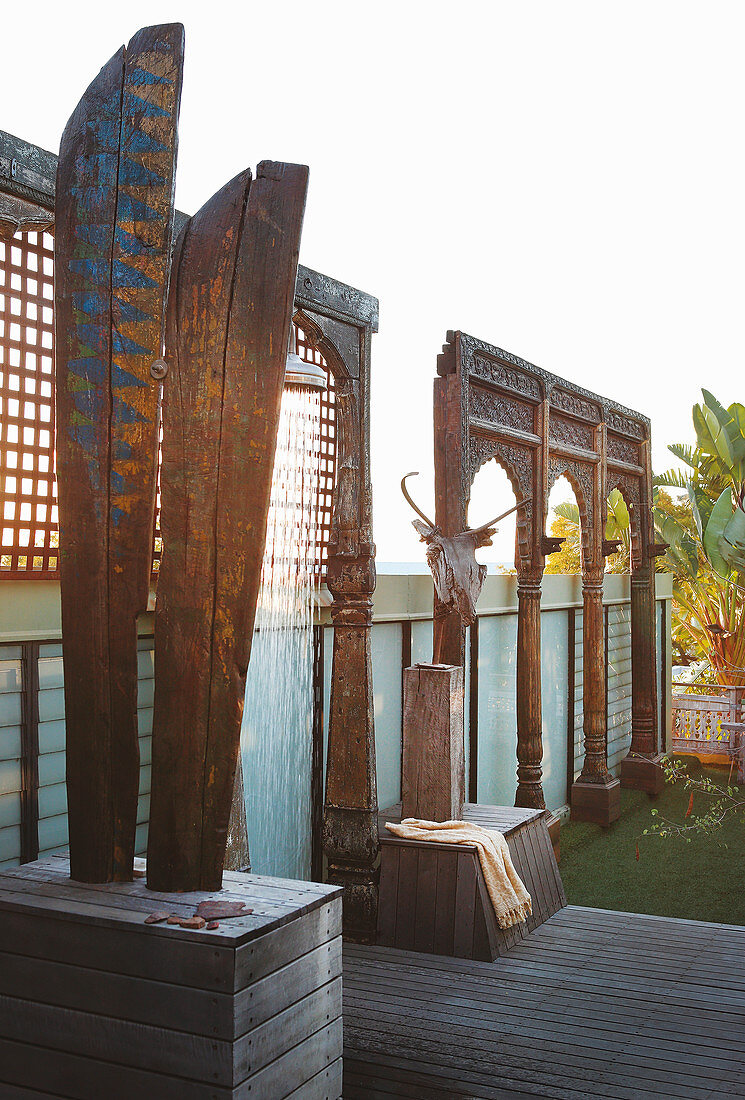 Wooden sculptures and outdoor shower on roof terrace