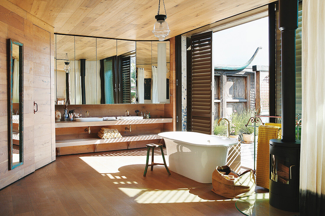 Free-standing bathtub in spacious bathroom with access to terrace
