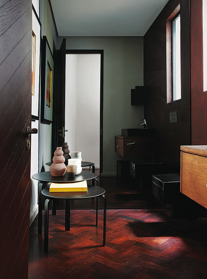 Nest of three tables in elegant guest bathroom with exotic-wood parquet flooring