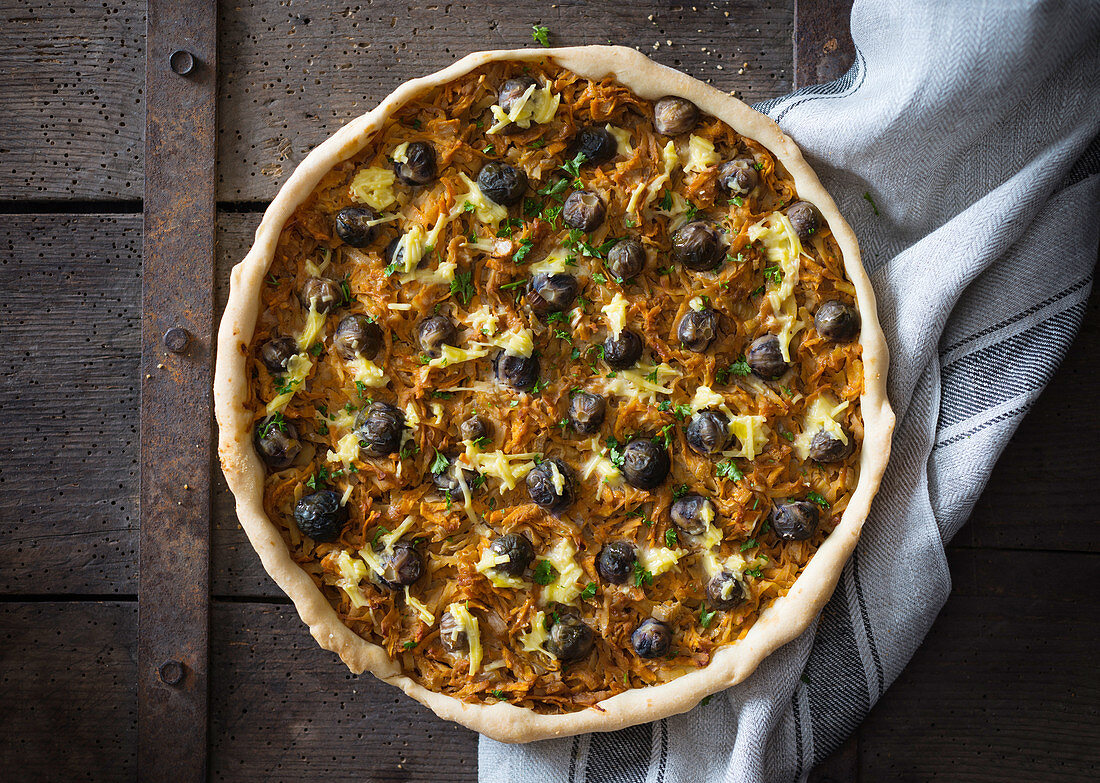 Vegane Quiche mit geraspelten Süsskartoffeln, violettem Rosenkohl und pflanzlichem Käse