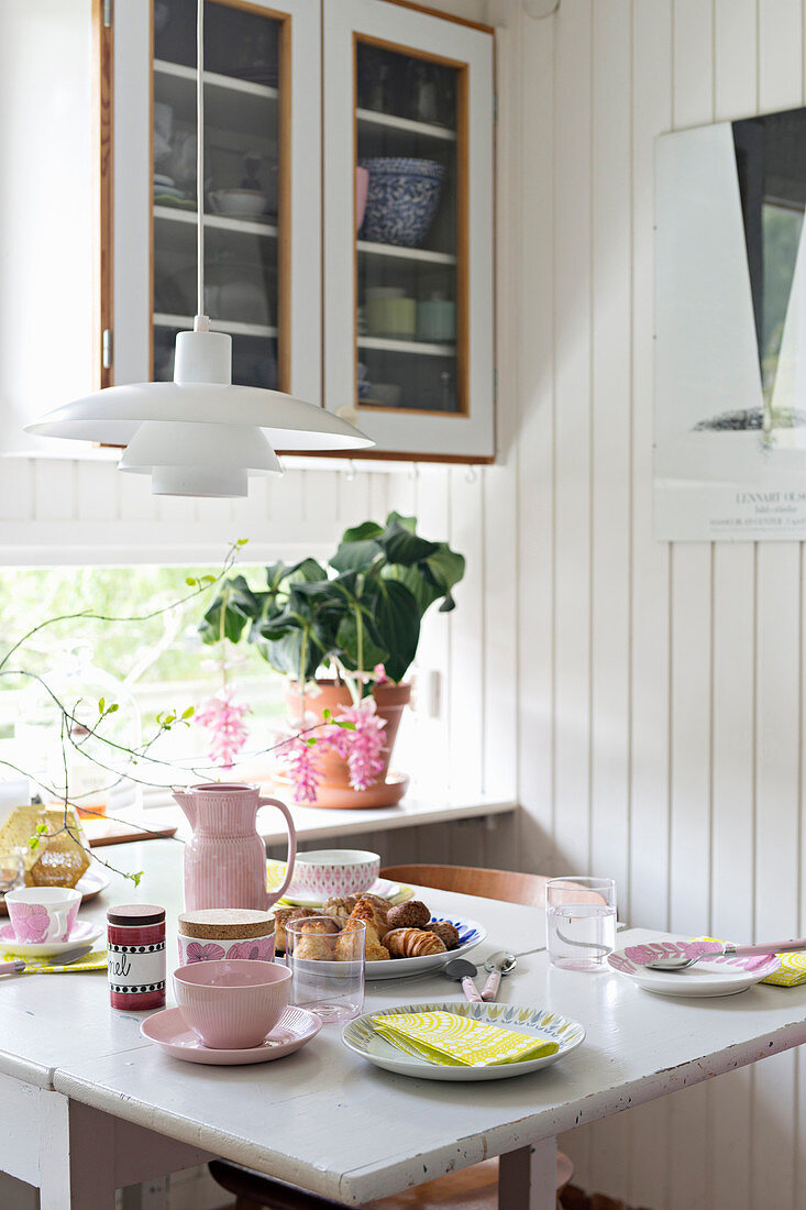 In Pastellfarben gedeckter Frühstückstisch in der Küche